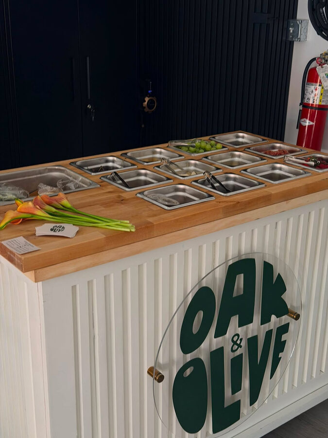 The Oak and Olive branded charcuterie cart at an outdoor party in Naples Florida